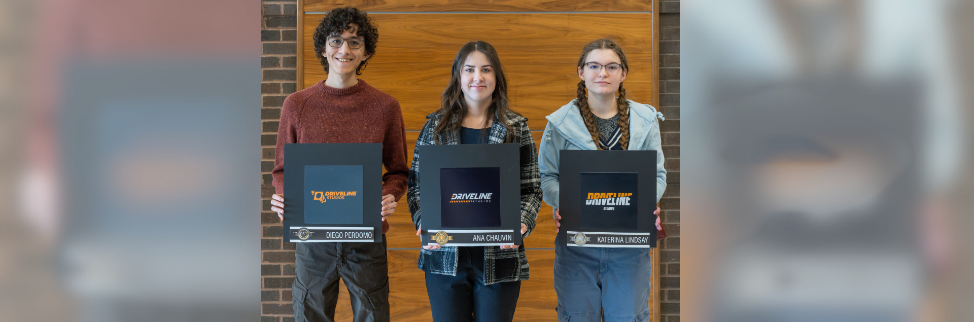 (From left to right) Diego Perdomo, student, third place winner; Ana Chauvin, student, first place winner; and Katarina Lindsay, student, second place winner, pose with their designs at the Driveline Studios logo design awards presentation.